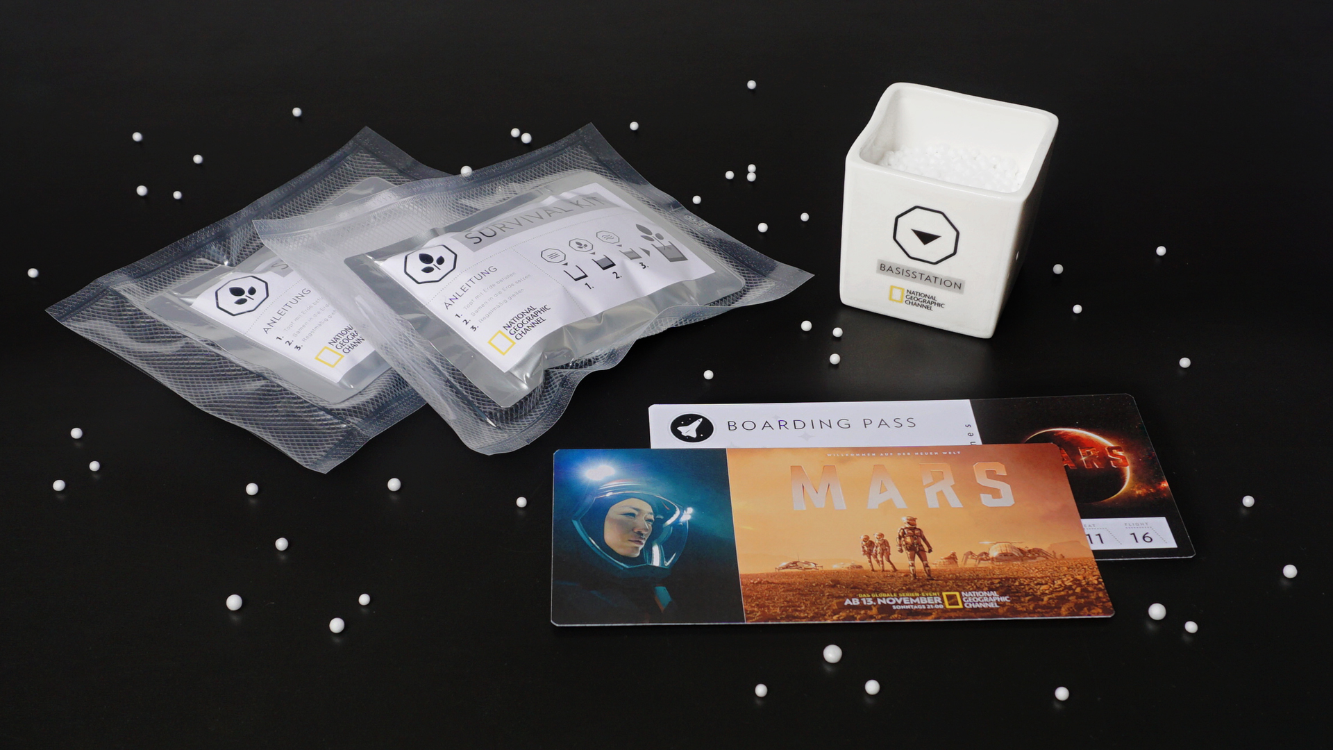 Die Inhalte eines Mailings zum Thema Mars liegen nebeneinander auf einer schwarzen Fläche