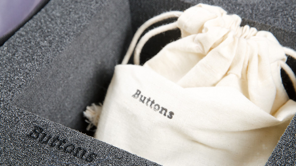 Nahaufnahme des Inneren des Koffers. Ein Beutel mit der Beschriftung „Buttons“.