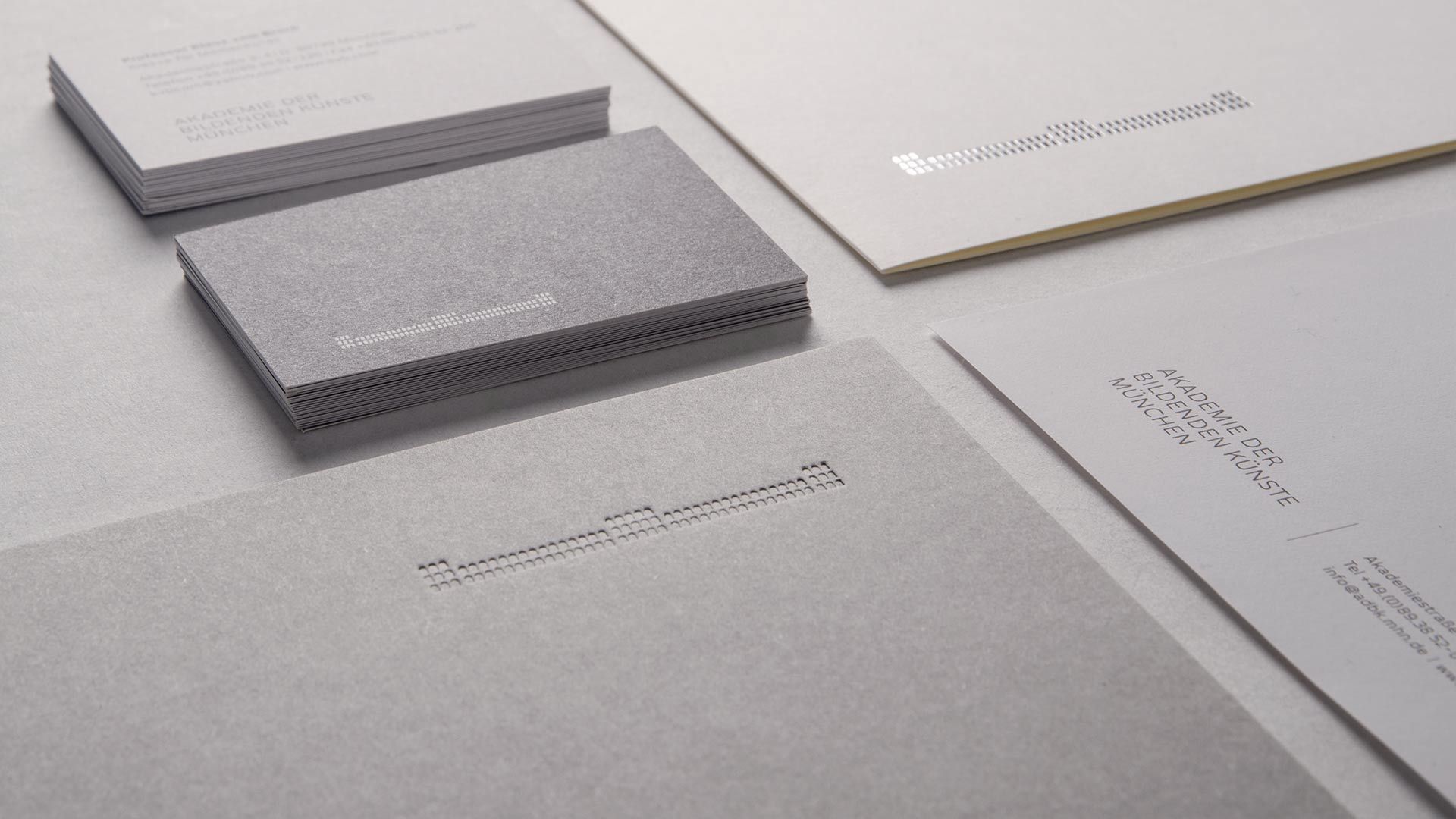 Detailansicht der Mappen und Visitenkarten mit Einprägung der Bildmarke. Branding Agentur München – Corporate Design Agentur entwickelt Geschäftsausstattung und visuelle Identität
