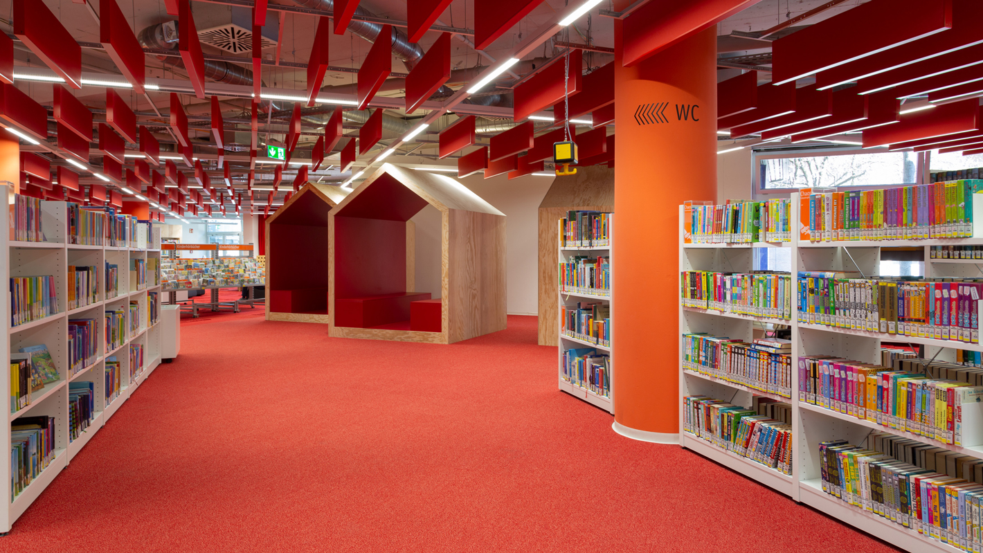 Die Innenraumgestaltung der Bibliothek im Motorama greift den Orangeton der marke teilweise auf.