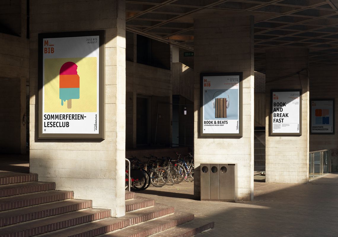 Im Eingangsbereich einer Bibliothek sind drei gestaltete Plakate der Stadtbibliothek zu sehen. Sie bewerben unterschiedliche Veranstaltungen, man erkennt aber sehr leicht, dass Sie von der gleichen marke stammen.