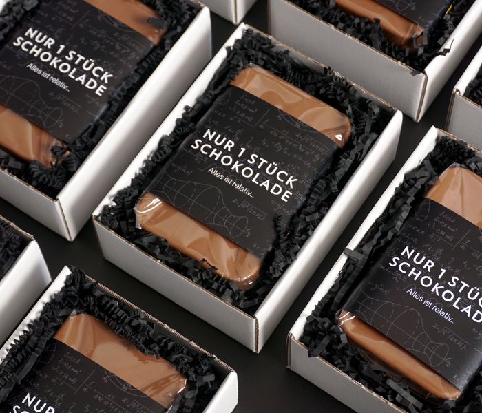 Nahaufnahme mehrerer Schokoladen in weißer Verpackung.