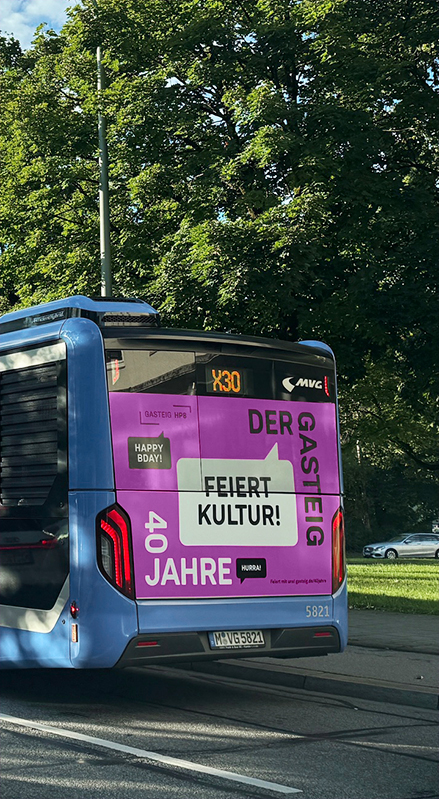 Bus im Münchner Stadtverkehr mit auffälligem Kampagnenmotiv „Feiert Kultur!“ zum 40-jährigen Jubiläum des Gasteig – Teil der großflächigen Imagekampagne im öffentlichen Raum.